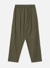 Olive brushed moleskin pleated track pants laid flat on a plain light grey studio backdrop. The elasticated waistband features a single dark button at the centre front. Pleats run from waist to thigh on each leg, with slanted side pockets. The wide leg tapers slightly toward the cropped hem.