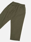 Olive brushed moleskin track pants laid flat on a white studio surface, angled view showing the back. Elasticated waistband with a buttoned flap pocket on the left hip and a single button-fastened welt pocket at centre back. Relaxed tapered leg in plain smooth olive fabric.