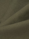 Close-up of olive brushed moleskin fabric, showing a soft, fine-knit texture with a subtle nap. The fabric is folded to reveal gentle creases and depth of colour, a muted khaki-green throughout. No garment details or background are visible.