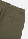Close-up flat lay of olive brushed moleskin military chinos on a white studio backdrop. The rear view shows the waistband with two belt loops, a welt back pocket fastened with a four-hole dark button, and blue contrast stitching detail at the pocket corner. The smooth, fine-textured fabric has a subtle twill weave.