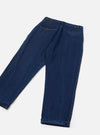 Indigo work denim super chino laid flat on a light grey seamless backdrop, showing the reverse side. Dark indigo denim with contrast stitching at the waistband. Two flap back pockets with copper stud buttons. One leg features a turned-up cuff at the hem. Relaxed wide leg cut visible throughout.