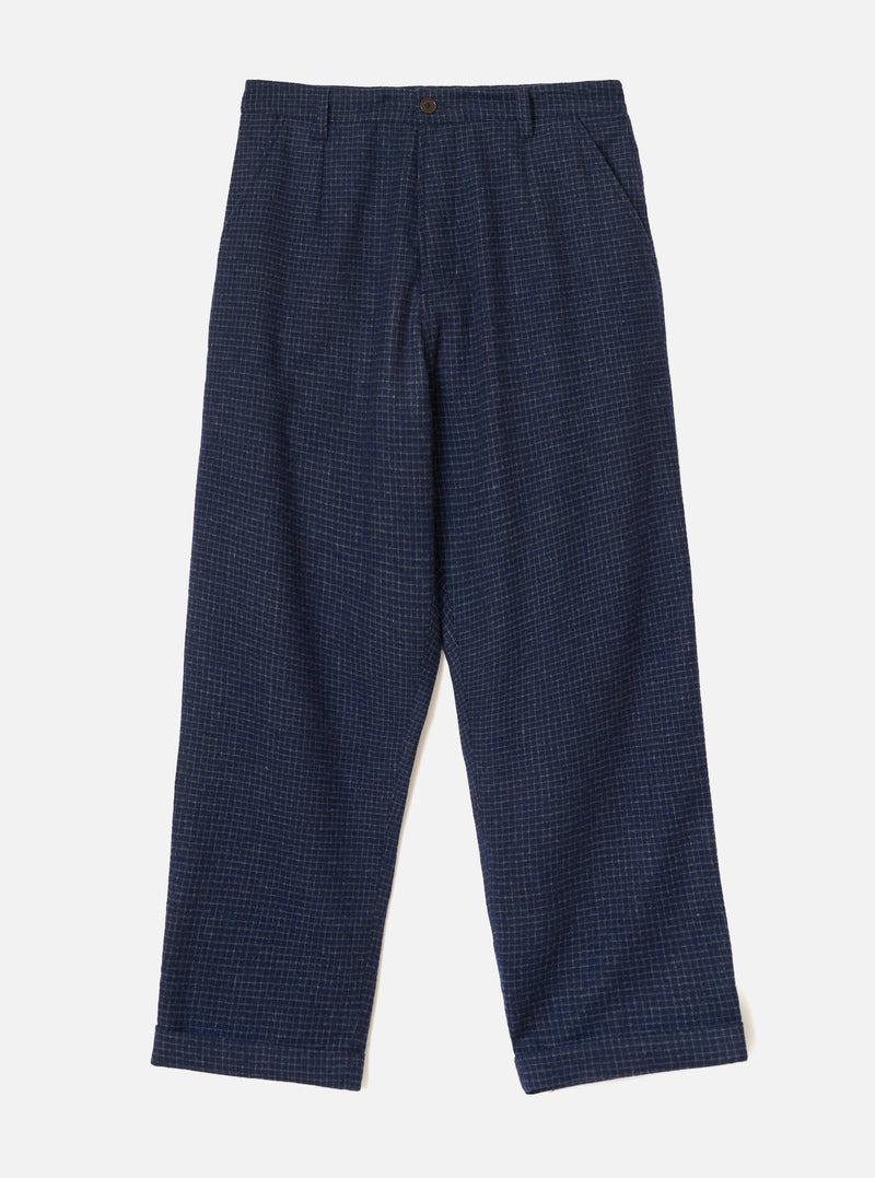 Navy check wool mix chinos laid flat on a light grey backdrop. The fabric features a fine grid check pattern in grey on navy. A single bronze button fastens the waistband, with a zip fly, front pleats, slanted side pockets, and turned-up cuffs at the full-length hem.