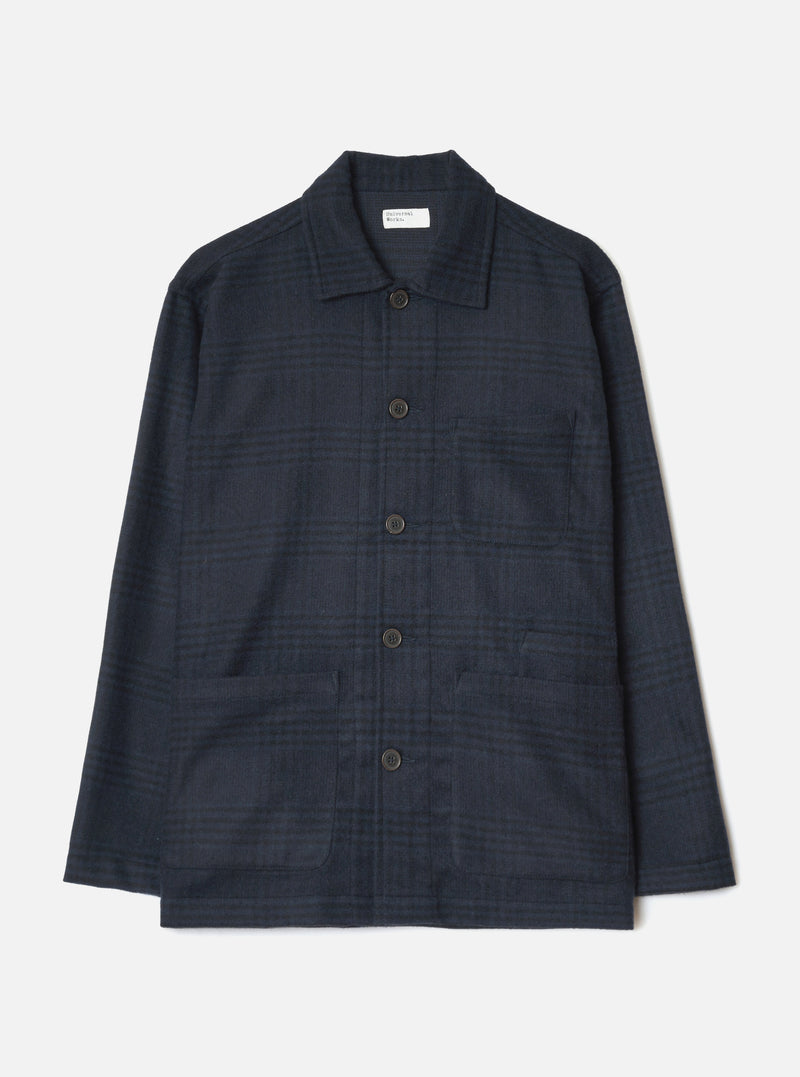 Navy wool mix bakers overshirt in a tonal check pattern, shot flat on a white studio backdrop. Features a spread collar, five dark horn-effect buttons down the centre front, one chest patch pocket, and two large lower patch pockets. Long sleeves with plain cuffs. A Universal Works woven label sits at the neck.