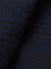 Close-up of the navy wool mix fabric of a bakers overshirt, showing a dense, lightly brushed texture with subtle blue and dark grey tonal variation. The fabric has a soft, boiled-wool-style surface with fine surface fibres visible throughout. No background is visible.