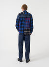 A rear view of a model wearing the Indigo Future Denim Troopers Fatigue Pant. The image showcases the back pockets, dark blue denim texture, and comfortable tailored fit of the trousers against a plain neutral backdrop.