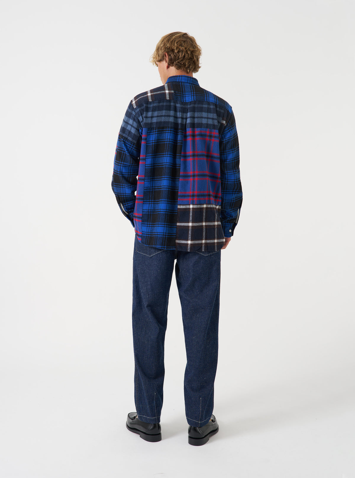 A rear view of a model wearing the Indigo Future Denim Troopers Fatigue Pant. The image showcases the back pockets, dark blue denim texture, and comfortable tailored fit of the trousers against a plain neutral backdrop.