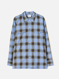 Blue check ombre plaid long-sleeve shirt laid flat on a light grey studio backdrop. Features a point collar, full-length button placket with white buttons, two flap chest pockets, and buttoned cuffs. The check pattern blends blue, navy and olive tones with a soft, diffused ombre effect.