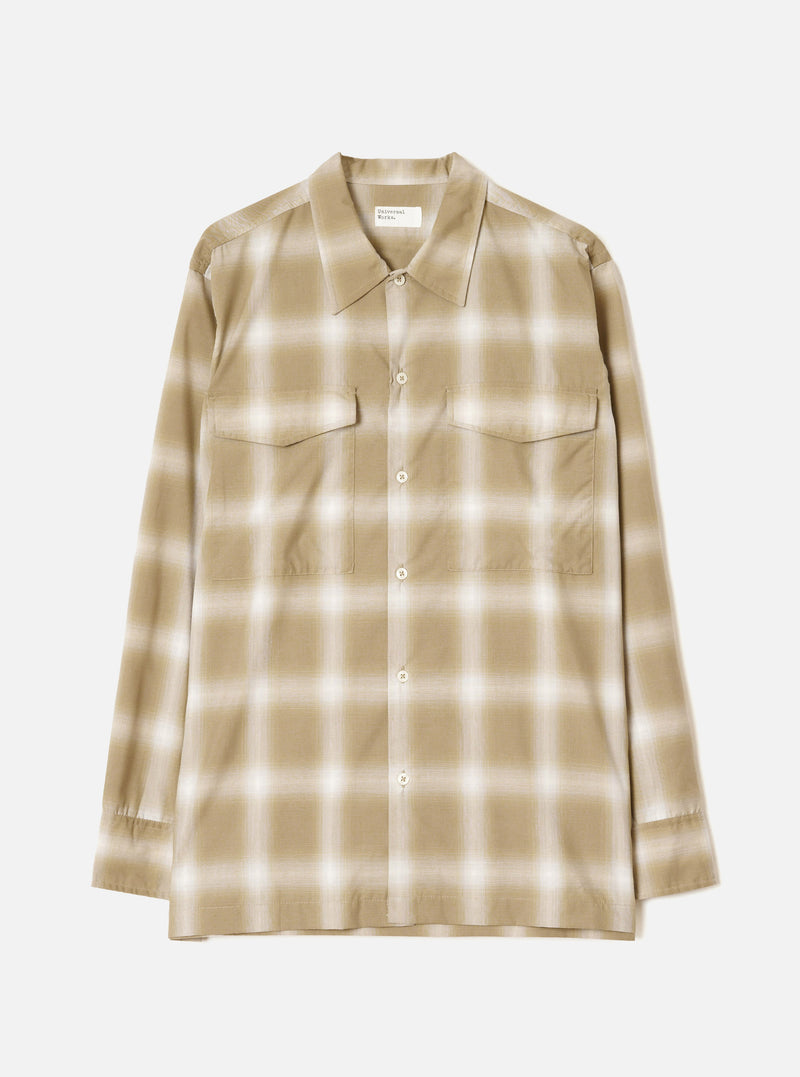 Sand and cream ombre check long-sleeve shirt laid flat on a light grey studio backdrop. Features a pointed collar, full-length button placket with cream buttons, two flap chest pockets, and buttoned cuffs. Universal Works woven label visible at the neckline.