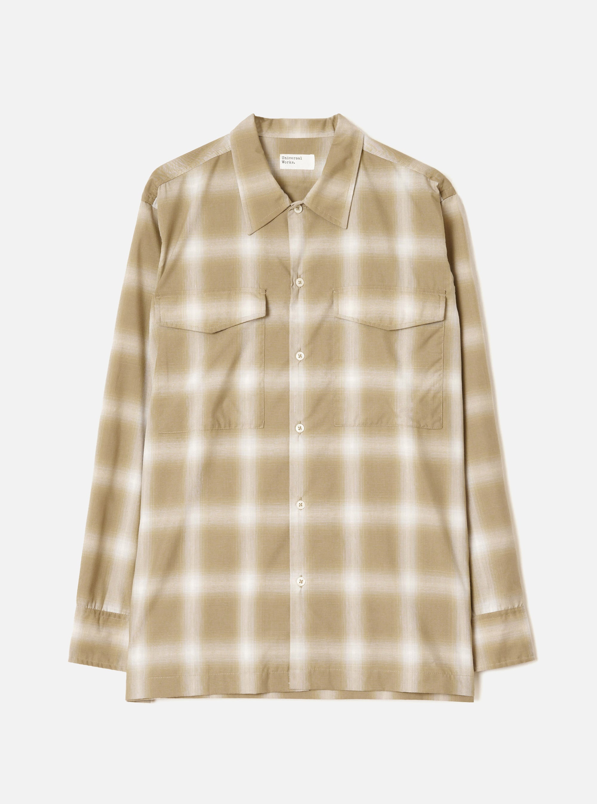 Sand and cream ombre check long-sleeve shirt laid flat on a light grey studio backdrop. Features a pointed collar, full-length button placket with cream buttons, two flap chest pockets, and buttoned cuffs. Universal Works woven label visible at the neckline.