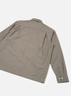 Flat lay of a sand and olive small gingham check shirt, shot from the back at an angle on a white studio surface. The spread collar, back yoke seam, and single long sleeve are visible. The cuff features two small cream buttons. Woven cotton fabric in a fine two-tone check.
