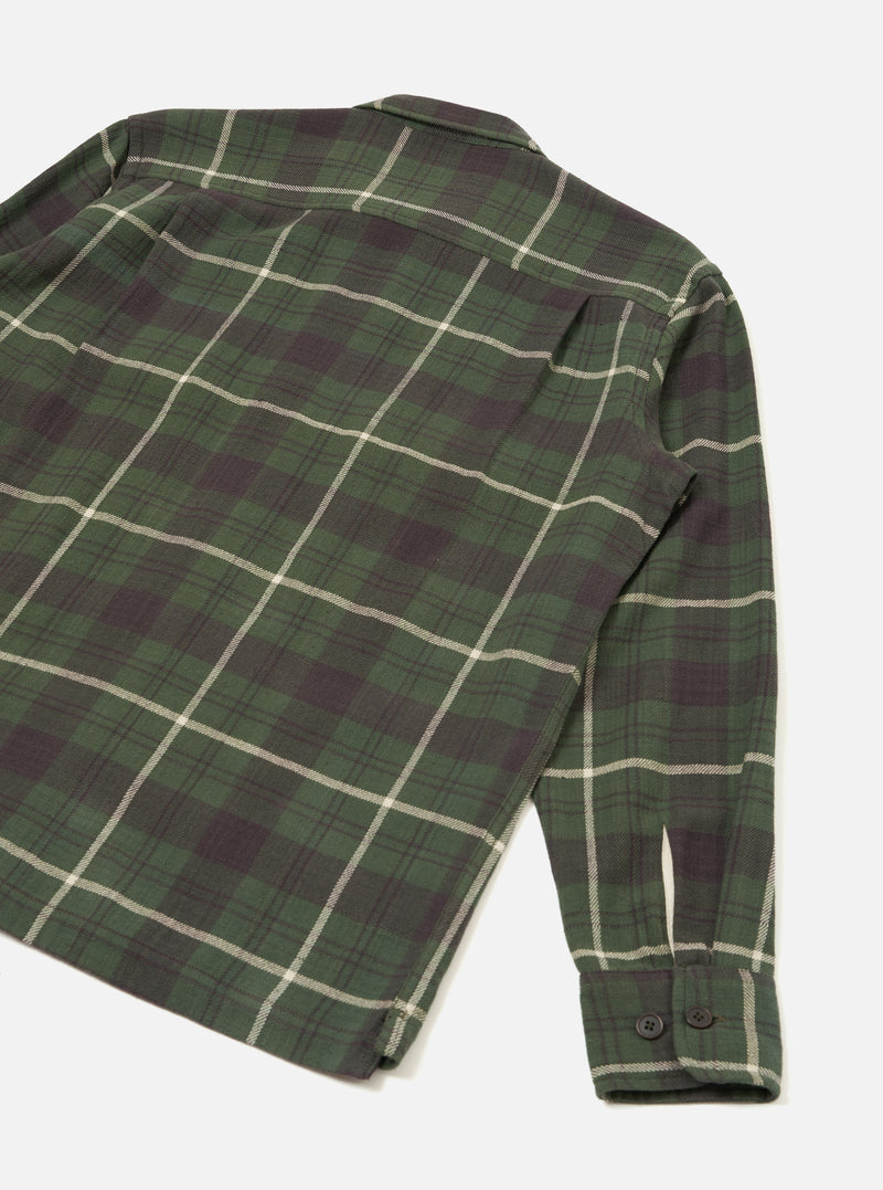 A product shot highlighting the back of the Universal Works Olive Washed Check L/S Utility Shirt laid flat on a plain background. The image displays the olive green check pattern, back yoke detail, relaxed cut, and straight cut hemline.