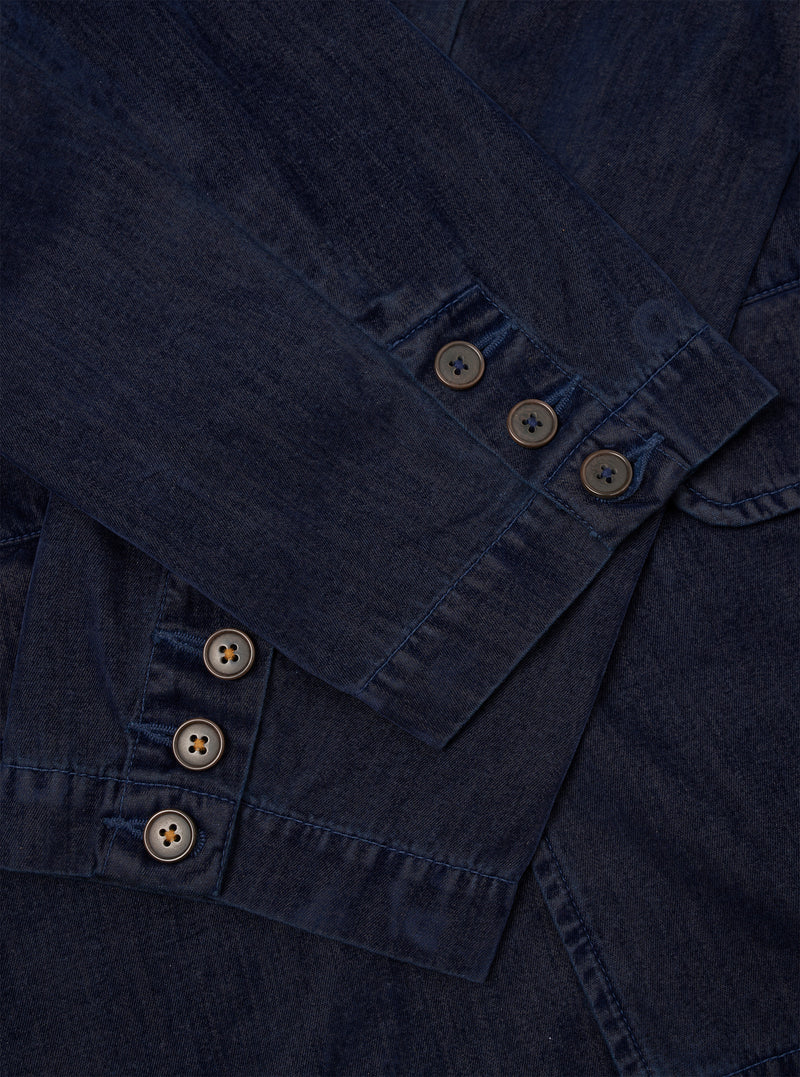 A close-up detail shot of the Navy Flock Chambray Warmus Jacket set against a plain background, highlighting the dark navy flock chambray cotton fabric texture, button details, pocket stitching, and fine tailoring.