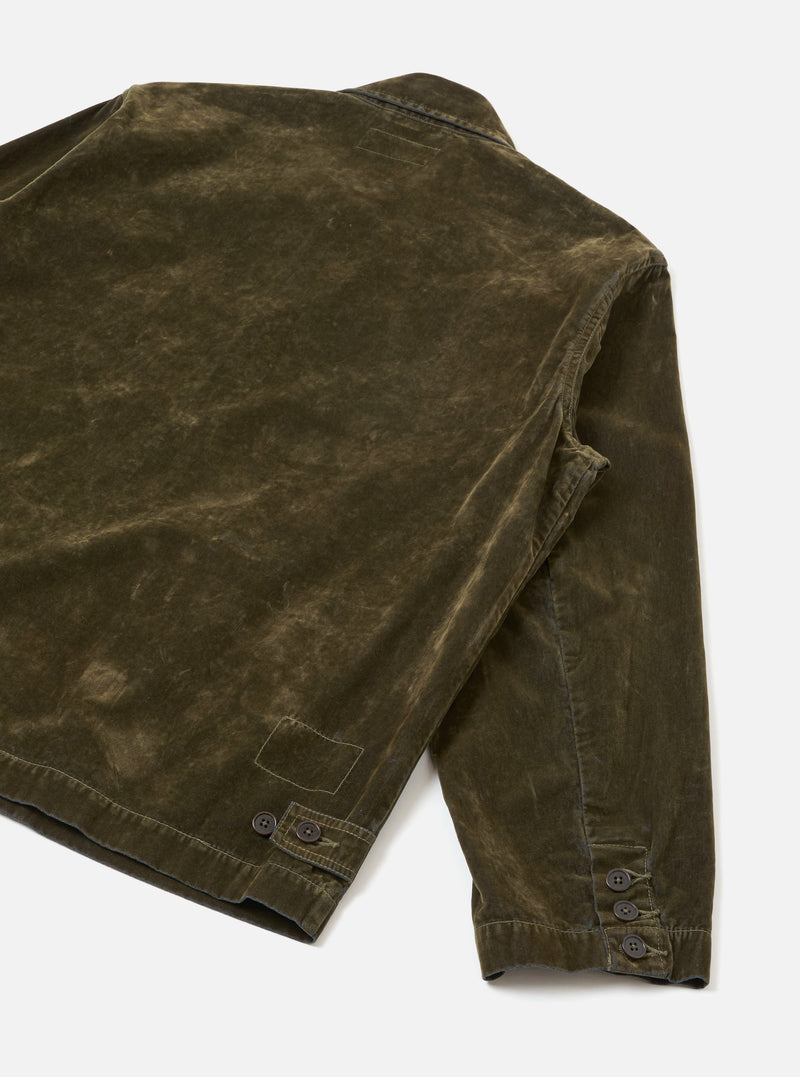 A back studio view of the Olive Flock Chambray Warmus Jacket set against a plain neutral backdrop. The olive green cotton jacket exhibits a smooth back panel, defined shoulder seams, and a straight hem cut.