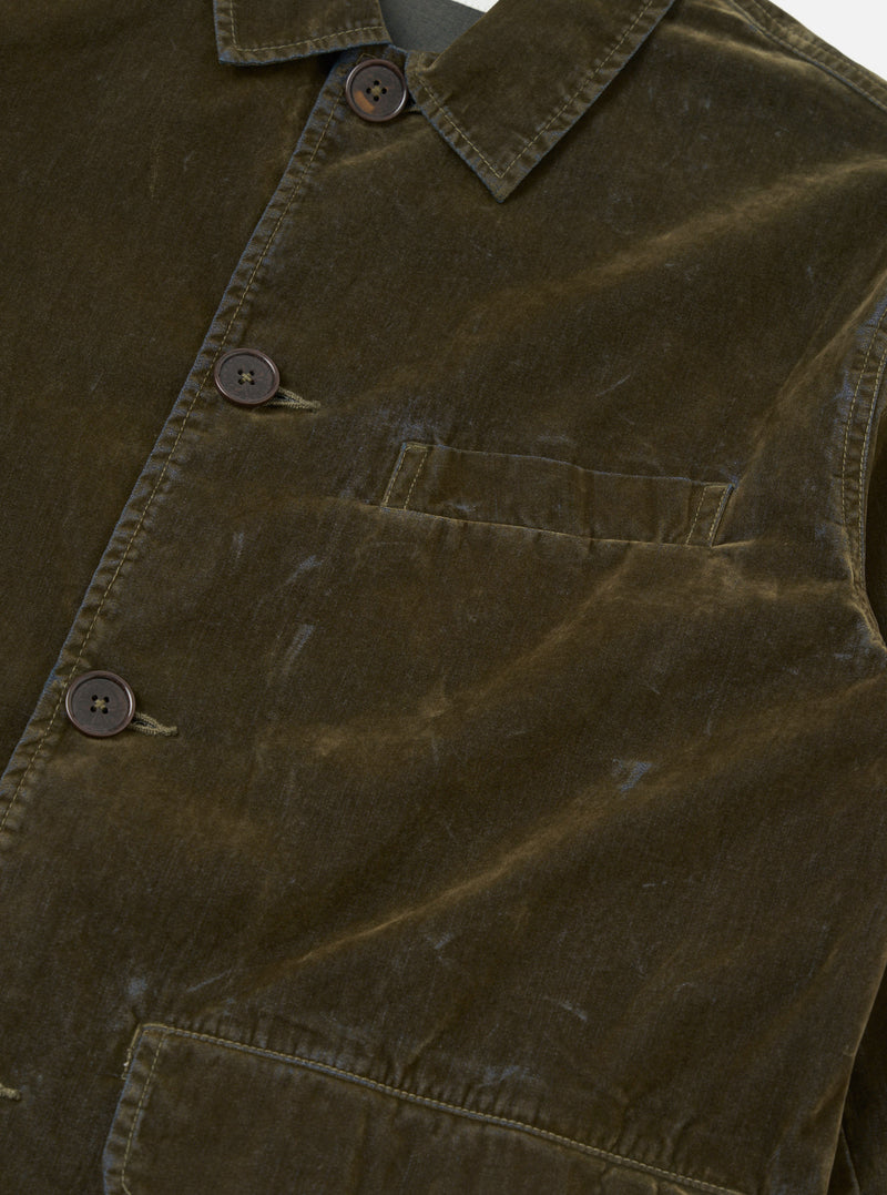 A close-up detail image of the Olive Flock Chambray Warmus Jacket set against a plain backdrop, showcasing the rich olive green flock chambray cotton fabric texture, precise stitching, and front button details.