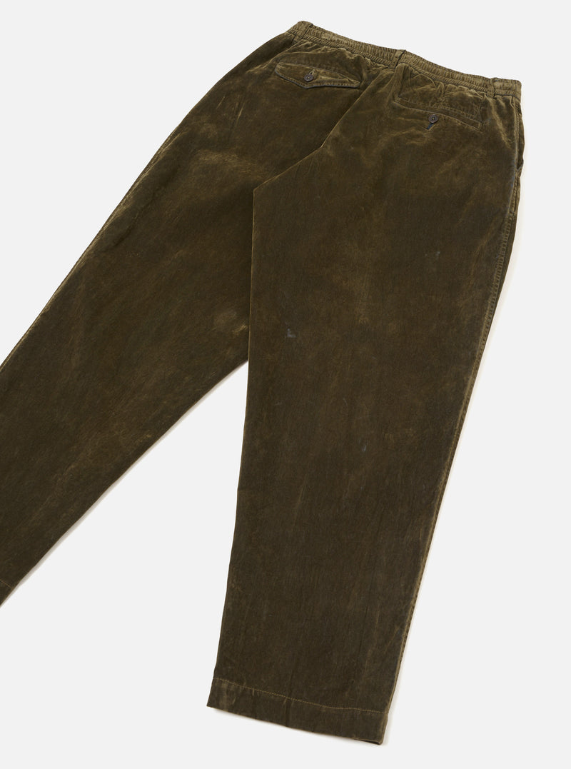 Rear view of the Universal Works Olive Flock Chambray Pleated Track Pant laid flat on a neutral background. Focuses on the olive green cotton chambray fabric, neat back welt pockets, and relaxed tapered leg cut.