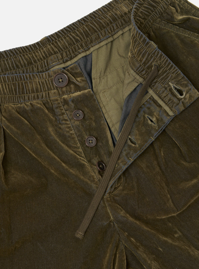 Close-up detail shot of the Universal Works Olive Flock Chambray Pleated Track Pant on a plain background. Highlights the pleated waist construction, adjustable drawstring closure, and fine textured olive cotton chambray finish.
