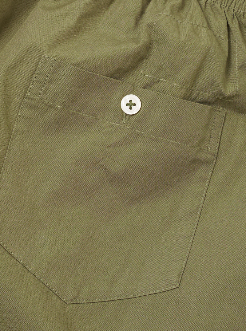 Rear view of the Universal Works Olive Broadcloth Boxer Shorts set against a plain white background, featuring a single small rear patch pocket, elasticated waist, and clean tonal stitching.