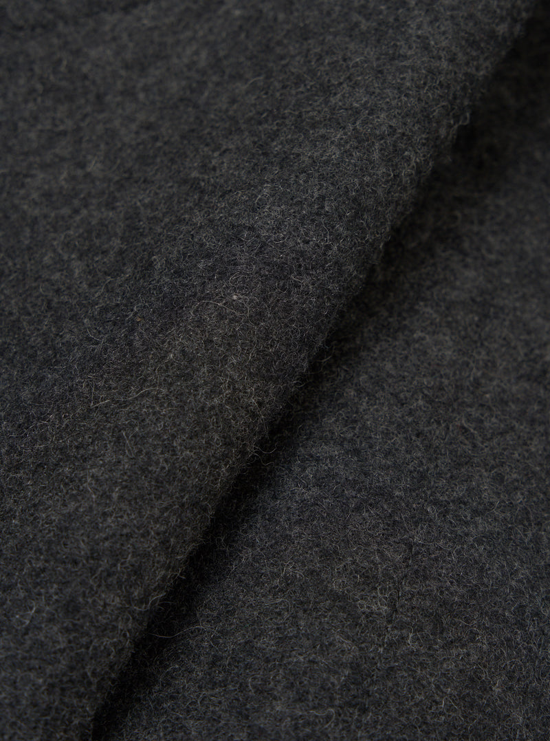 Close-up fabric detail of the grey marl Mowbray Boston Parka. The shot shows the charcoal marl wool-effect fabric folded and rolled, revealing its dense, lightly brushed texture with fine flecks throughout. No garment details or construction features are visible.