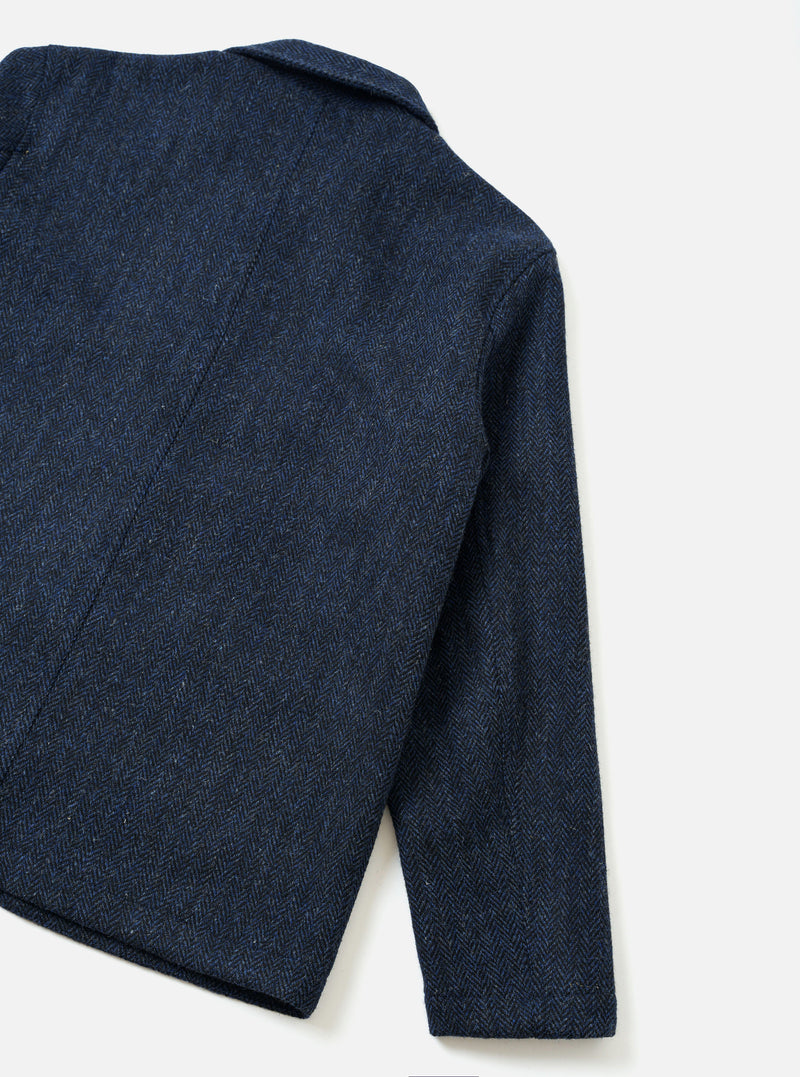 Back product view of the Blue/Black Harris Tweed OG Bakers Chore Jacket set against a plain background. The shot highlights the textured dark wool weave, clean back panel, and straight hemline of the chore jacket.