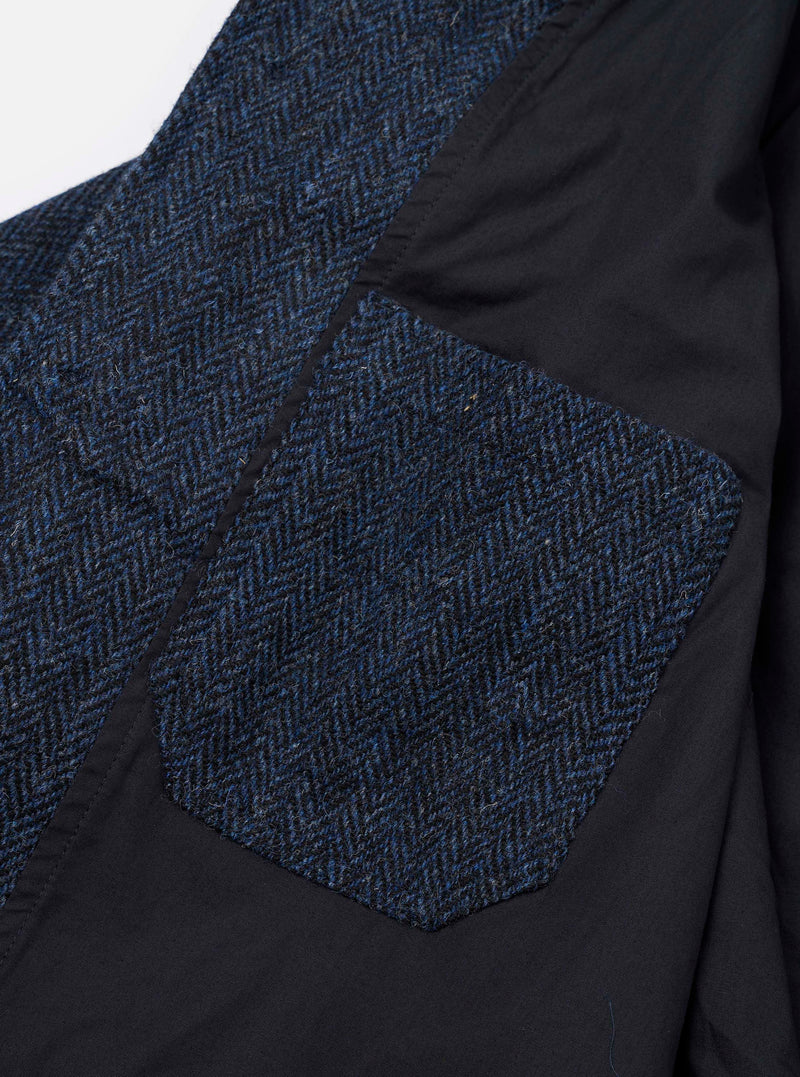 Detail view of the sleeve cuff and pocket stitching on the Blue/Black Harris Tweed OG Bakers Chore Jacket set against a plain backdrop, displaying the intricate dark tweed wool texture.