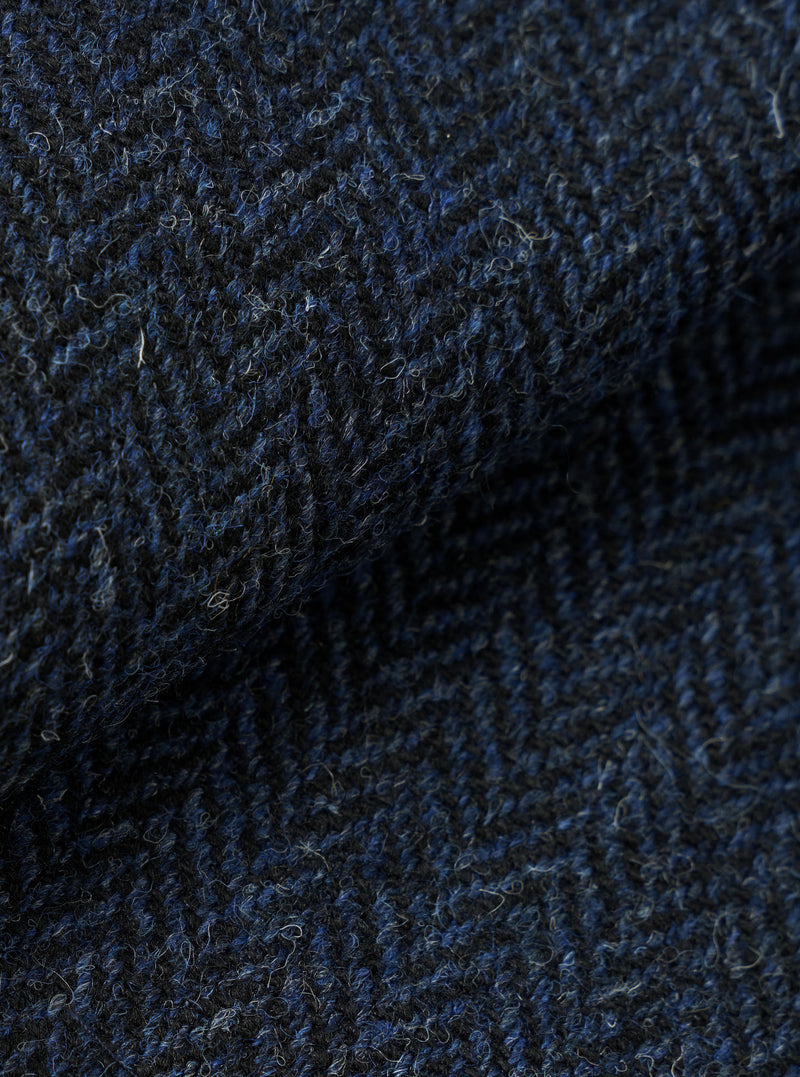 A close-up fabric swatch of the Blue/Black Harris Tweed OG Bakers Chore Jacket, displaying the detailed weave, texture, and color variation of the blue and black Harris Tweed wool material.