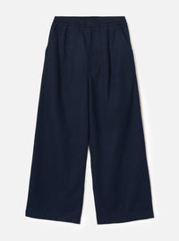 Navy wool herringbone wide-leg trousers laid flat on a plain light grey backdrop. The elasticated waistband features a single dark metal button at the centre front. Two side slash pockets sit at the hips. The fabric has a subtle herringbone texture throughout. Full-length legs with a wide, relaxed silhouette and plain hem.