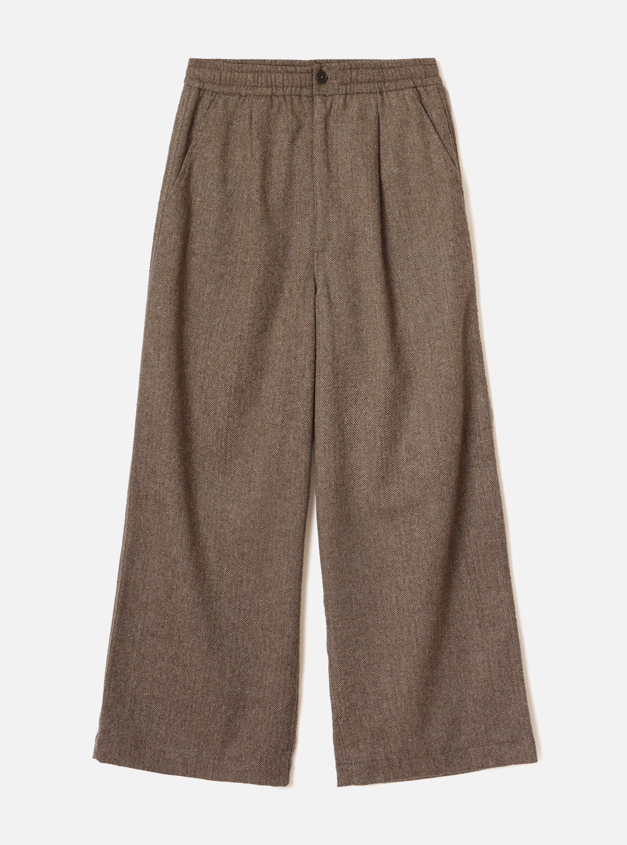Brown wool herringbone wide-leg trousers laid flat on a plain white background. The elasticated waistband features a single dark button at centre front. Slanted side pockets sit below the waistband. The fabric shows a classic herringbone weave in brown and cream tones. Full-length legs with a generous wide leg and plain hem.