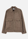 Brown wool herringbone zip-through jacket, flat lay on a plain light grey background. Features a point collar, central metal zip, two large chest patch pockets with button-fastened flaps, and plain cuffs. A Universal Works label is visible at the neck. The dark brown lining is visible at the collar.