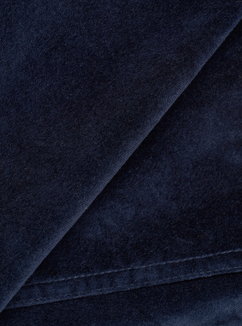 Close-up detail of the navy velvet fabric used in the CPH Zip OS Shirt. The shot highlights the dense, soft pile of the velvet with a folded edge running diagonally across the frame, revealing the fabric's depth and slight sheen against a dark navy ground.