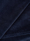 Close-up detail of the navy velvet fabric used in the CPH Zip OS Shirt. The shot highlights the dense, soft pile of the velvet with a folded edge running diagonally across the frame, revealing the fabric's depth and slight sheen against a dark navy ground.