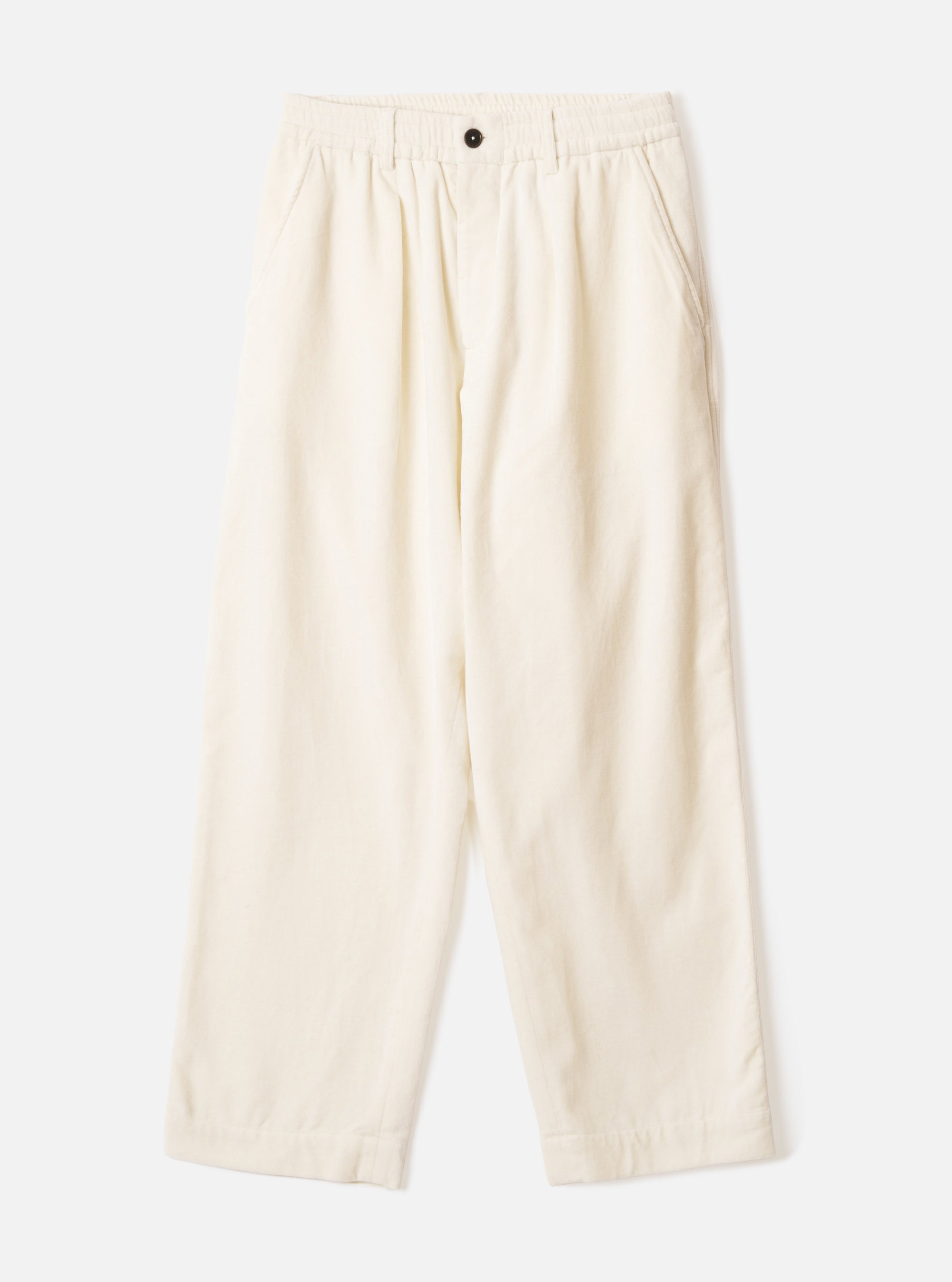 Ecru wide-leg velvet oxford trousers laid flat on a light grey background. The elasticated waistband features a single dark button at the centre front. Slash pockets sit at the hips. The fabric has a soft, fine-ribbed velvet texture. The silhouette is relaxed through the leg with a full-length hem.