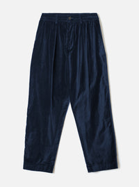 Navy velvet Oxford trousers laid flat on a light grey studio backdrop. Fine-wale velvet fabric with a subtle sheen. Elasticated waistband with a single centre button, double forward pleats, side slash pockets, and tapered legs with plain hems.