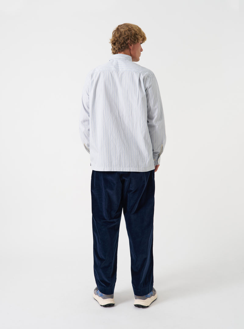 A back view of a model wearing the Navy CPH Velvet Oxford Pant. The photograph captures the rear fit of the navy velvet trousers, emphasizing the wide cut leg, subtle sheen of the fabric, and hem detail against a plain background.