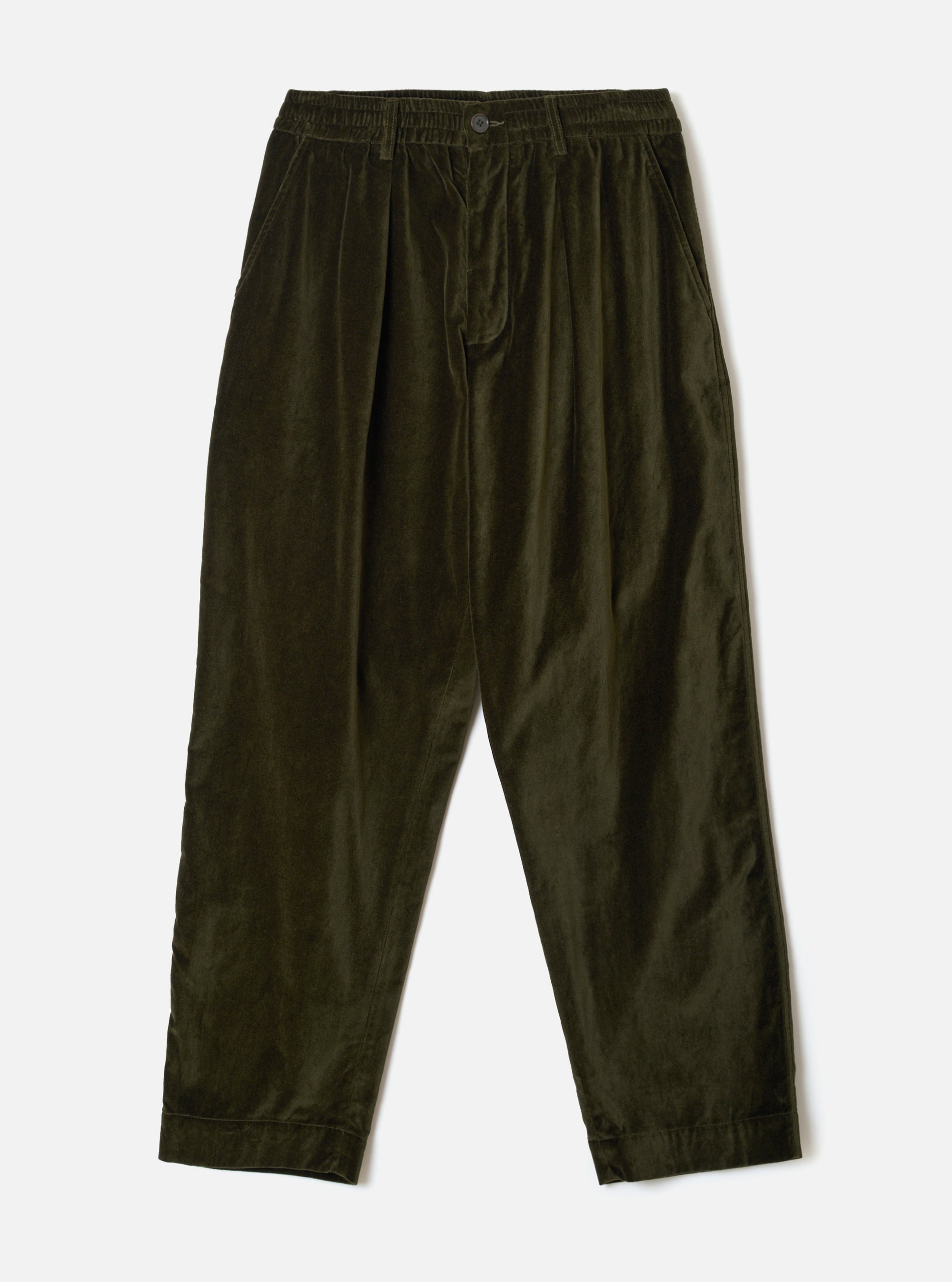 Olive velvet Oxford trousers laid flat on a light grey seamless backdrop. Fine-wale velvet fabric with a soft sheen. Elasticated waistband with a single button fastening, twin pleats at the front, and side slash pockets. Tapered leg with turned-up cuffs at the ankle hem.
