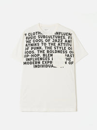 Ecru single jersey pocket tee laid flat on a light grey seamless backdrop. A bold black all-caps text graphic covers the chest, referencing music subcultures including jazz, punk, mods and hip-hop. A small patch chest pocket sits within the graphic. Crew neck, short sleeves and a Universal Works neck label visible.