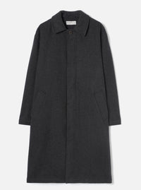 Grey marl wool overcoat laid flat on a light grey seamless backdrop. Features a point collar, concealed fly front with a single visible dark button at the neck, two large patch pockets at the lower front, and long plain sleeves. The coat reaches below the knee in a relaxed silhouette. Fabric has a soft, lightly flecked marl texture.