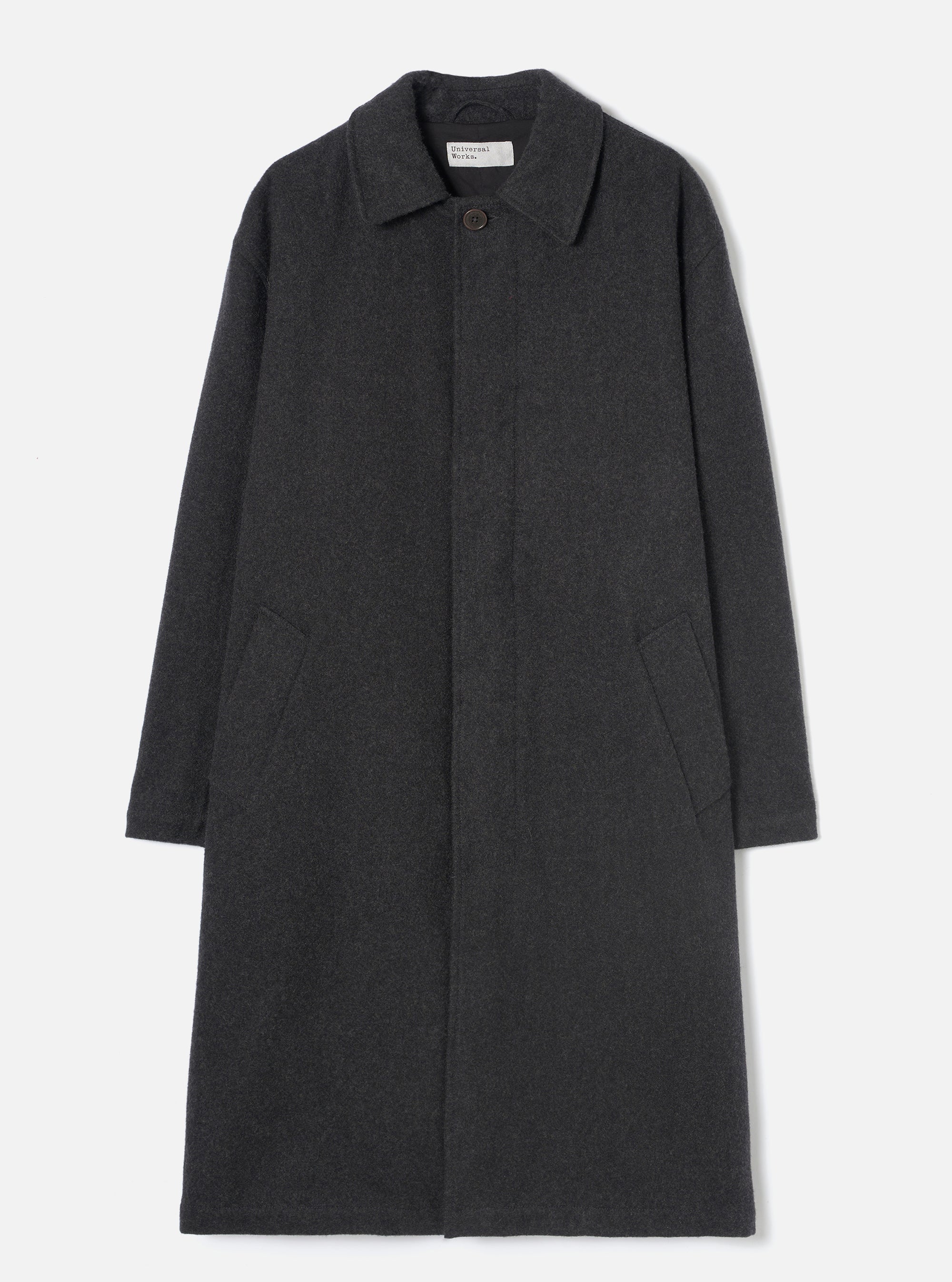 Grey marl wool overcoat laid flat on a light grey seamless backdrop. Features a point collar, concealed fly front with a single visible dark button at the neck, two large patch pockets at the lower front, and long plain sleeves. The coat reaches below the knee in a relaxed silhouette. Fabric has a soft, lightly flecked marl texture.