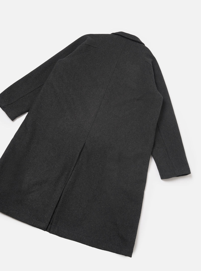 Grey marl wool-blend mac coat laid flat on a white studio surface, showing the back. A centre back seam runs the full length with a vent at the hem. Notched collar visible at the top. Plain cuffs at sleeve ends. Fabric has a fine mélange texture throughout.