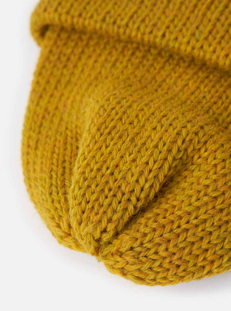 A close-up texture shot of the Mustard British Wool Short Watch Cap against a plain background, highlighting the 5-gauge single rib knit pattern made from warm, pure British wool fabric.