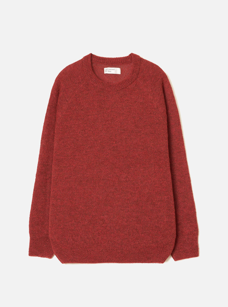 Deep orange marl alpaca knit crew neck jumper, flat lay on a light grey seamless backdrop. Ribbed crew neckline with a woven brand label at the back, ribbed cuffs and hem. Soft, fluffy knit texture throughout with a relaxed, boxy silhouette and long sleeves.