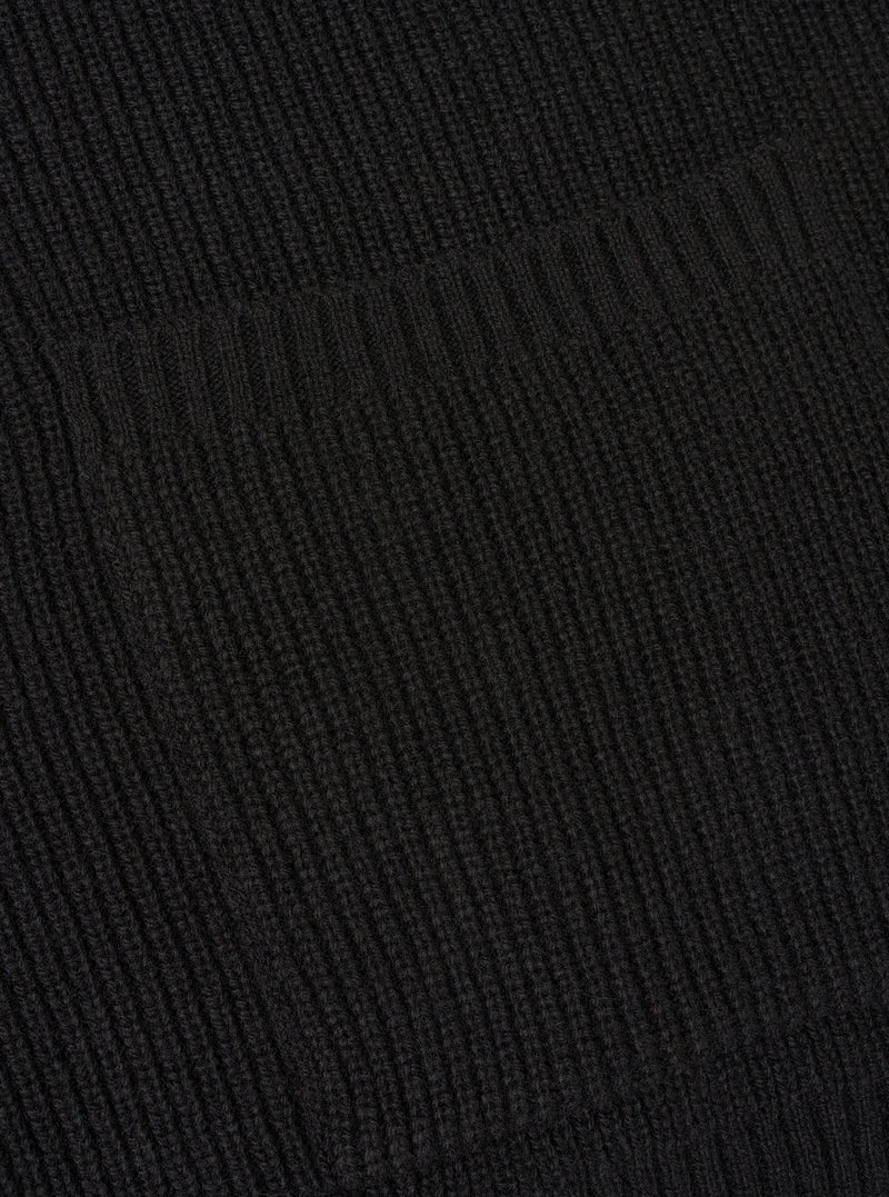 A close-up angle of the Black Eco Wool Zip Cardigan against a plain white studio background. The image highlights the fine ribbed knit cuffs, hemline stitching, and rich black eco wool yarn texture of the long-sleeved garment.