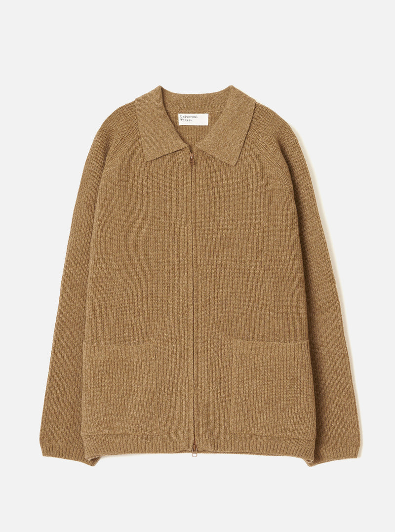 Tawny eco wool zip cardigan in camel marl, flat lay on a light grey seamless backdrop. Ribbed knit throughout with a spread collar, full-length bronze zip and two patch pockets at the hem. Ribbed cuffs and hem band. Universal Works woven label at the neckline.