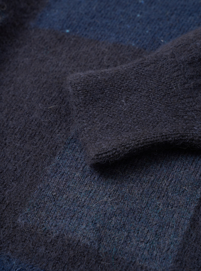 Close-up detail shot of the Navy British Wool Lyon Crew sweater against a plain white background. Highlights the ribbed crew neckline, raglan sleeve stitching, and deep texture of the premium marled navy blue British wool yarn.