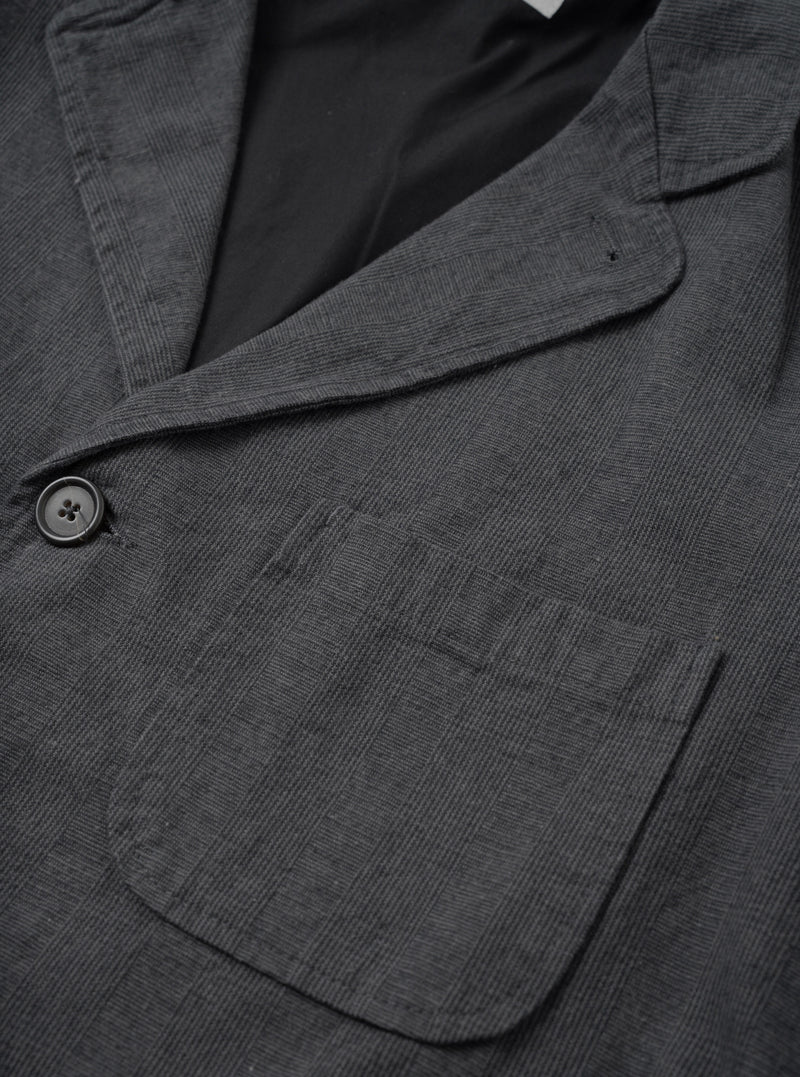 A close-up detail shot of the Grey Liverpool Check Three Button Jacket on a white background, focusing on the three-button front placket, notched lapel stitching, horn buttons, and textured grey cotton-linen check material.
