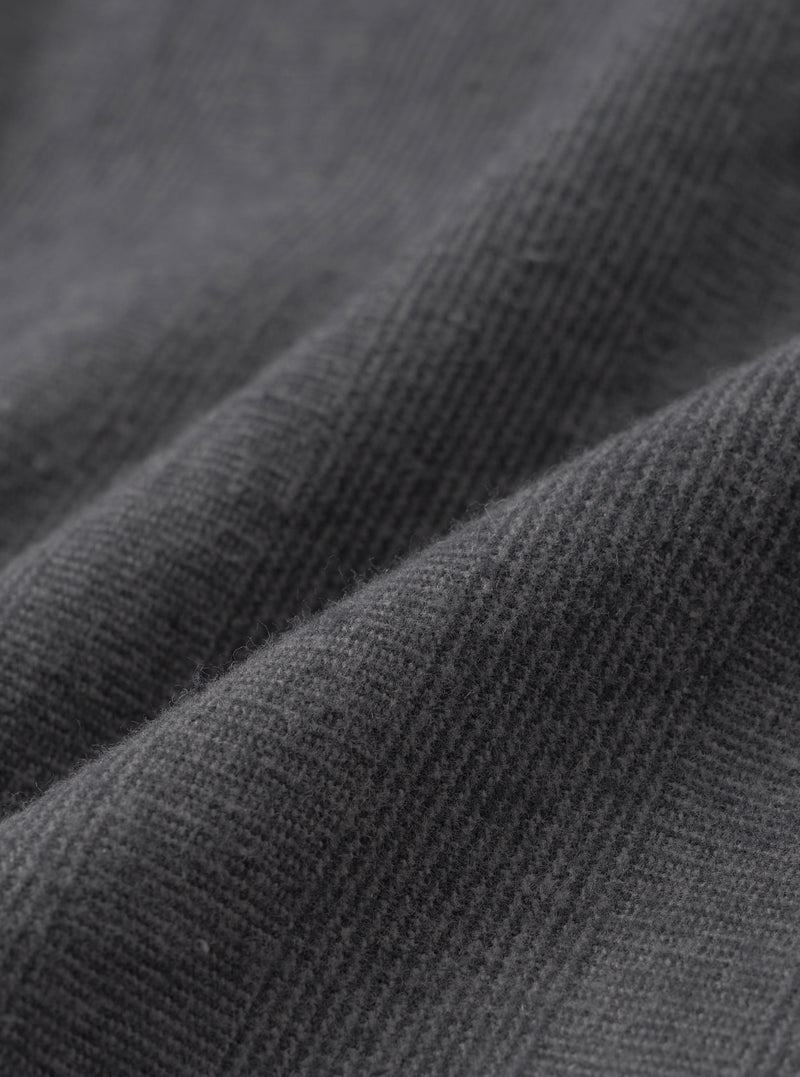A close-up swatch image showcasing the fabric pattern of the Grey Liverpool Check Oxford Pant on a white background. The shot details the crisscross grey checked weave and natural texture of the cotton and linen blend material.