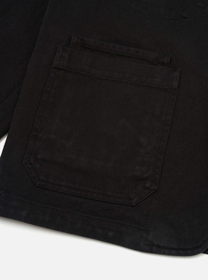Side view of the Black Dexter Twill OG Bakers Chore Jacket presented against a clean white background. This angle highlights the classic sleeve construction, side seams, and structured fit of the black organic cotton twill fabric.