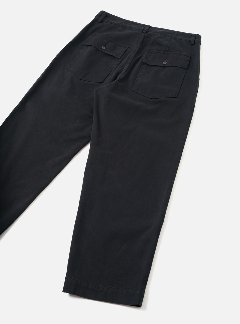 Back view of the Black Dexter Twill Grad Chino presented against a clean off-white background. The shot highlights the military fatigue inspired back pockets, rear seam construction, and organic cotton twill fabric.