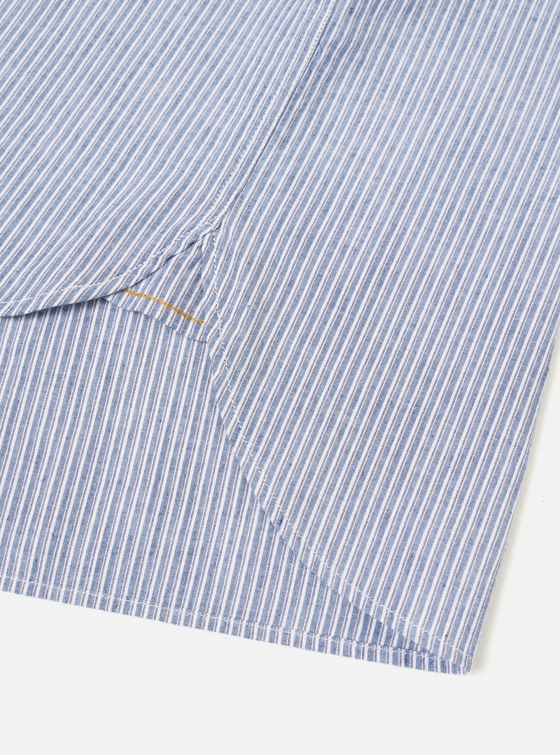 Close-up detail shot of the Blue Montgomery Stripe Station Shirt against a neutral backdrop. The image emphasizes the fine woven cotton stripe texture, precise stitching along the chest pocket, and high-quality front button closures.