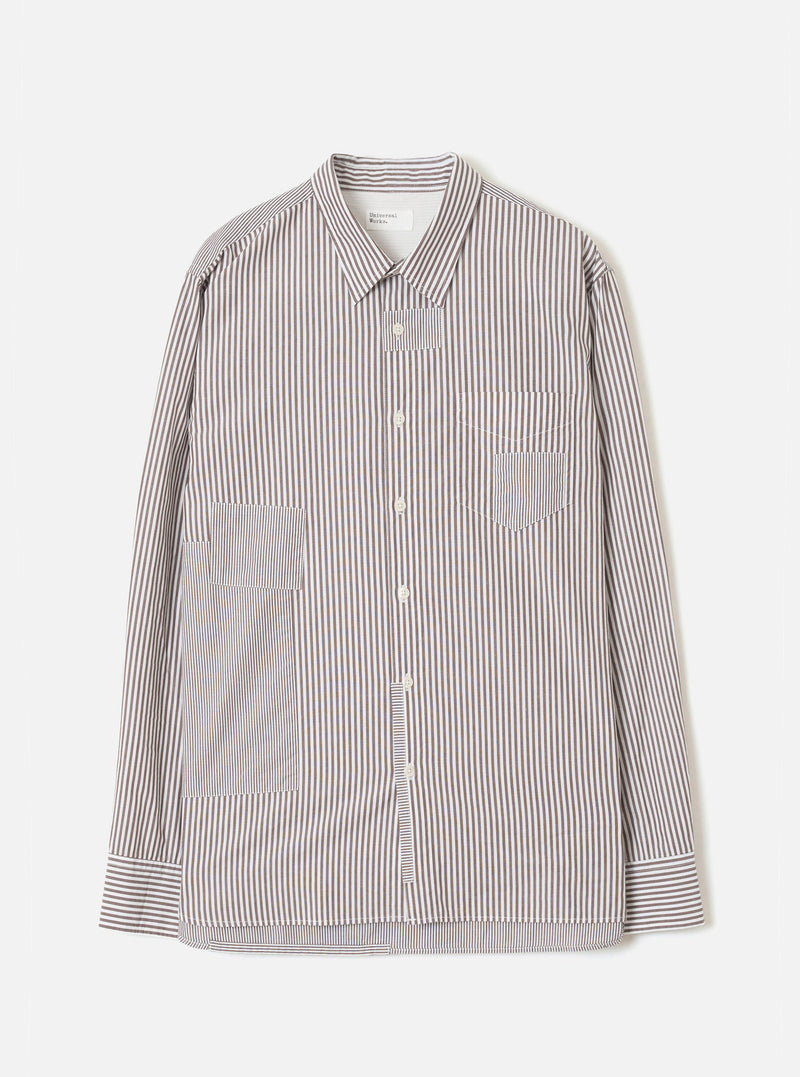 Brown and white vertical stripe cotton shirt, flat lay on a light grey backdrop. Point collar, front button placket with cream buttons, chest patch pocket, two large lower patch pockets, and button cuffs. Universal Works label visible at neck.