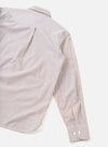 Brown and white fine-stripe cotton shirt laid flat on a white surface, shot from above at an angle. The back yoke, collar and one long sleeve are visible. The cuff features two white buttons and sits fully extended. Fabric has a crisp poplin texture.